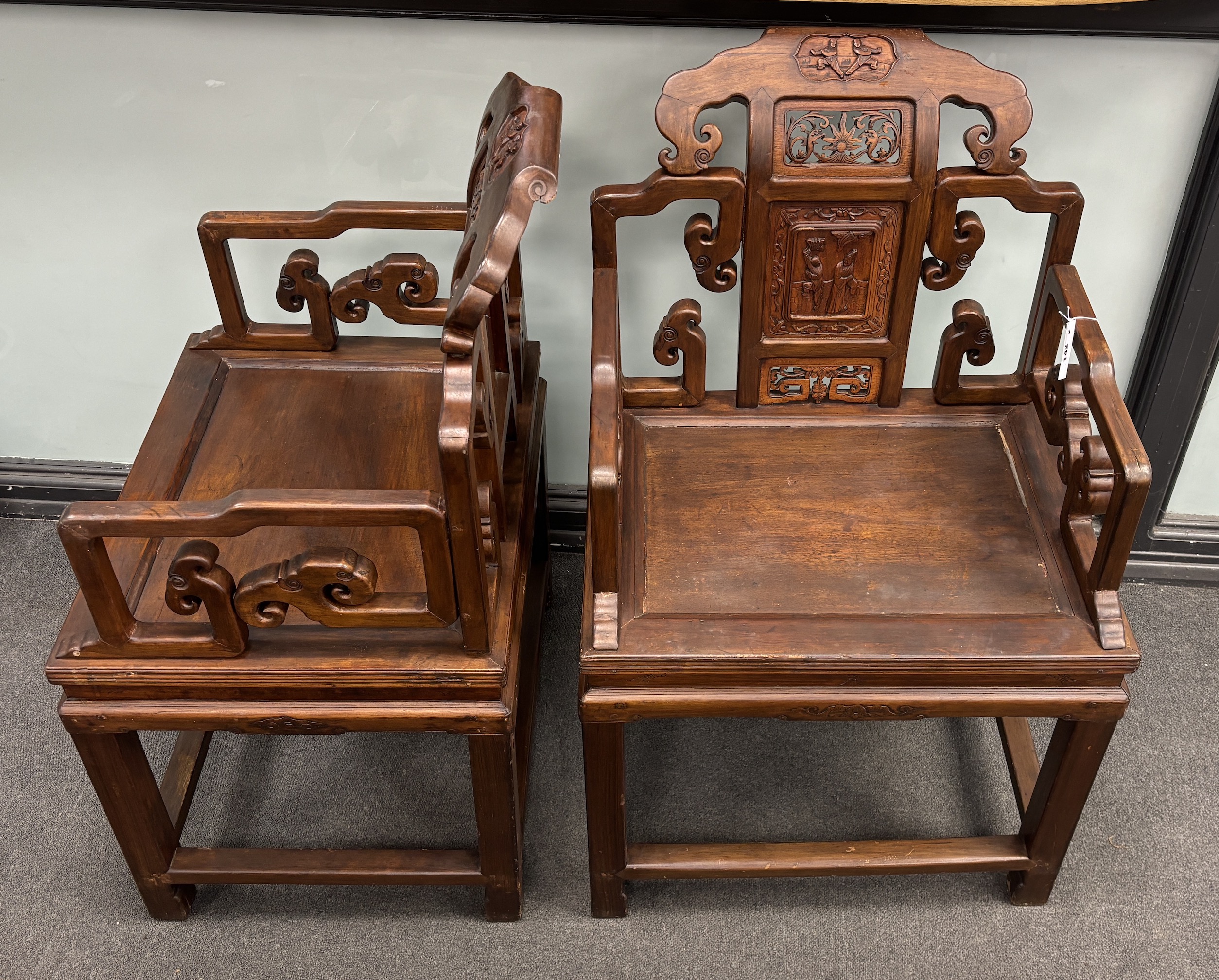 A pair of Chinese carved hardwood elbow chairs width 65cm, depth 52cm, height 103cm.